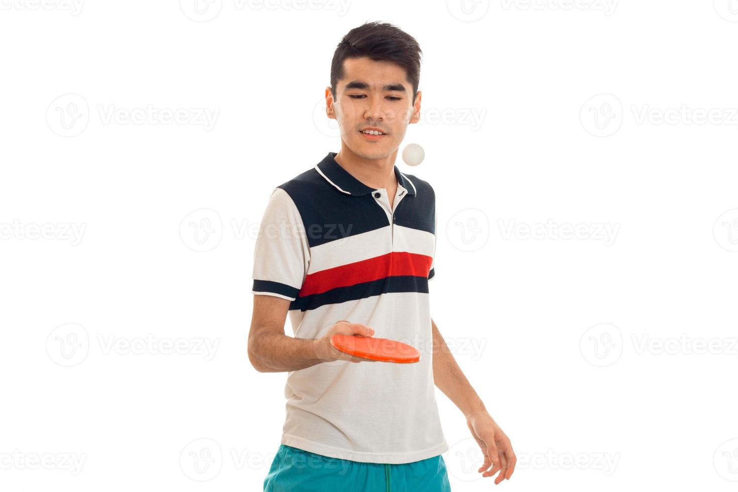 koncentrerad ung brunett man spelar pingis isolerat på vit bakgrund foto