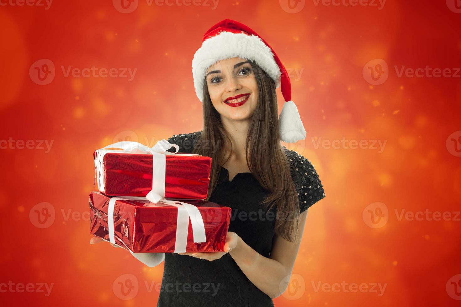 attraktiv flicka i santa hatt med röd gåva foto