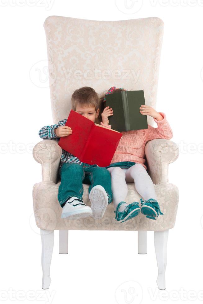 barn sitta i en stol med böcker foto