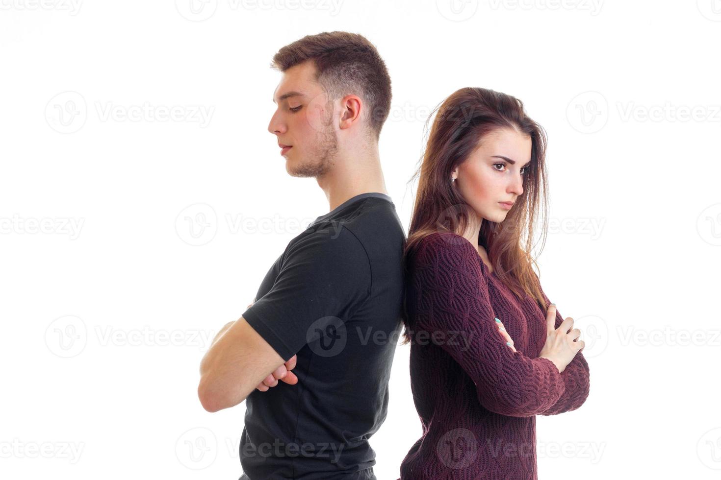 ung kille och flicka stå ryggar till varje Övrig med vikta händer foto