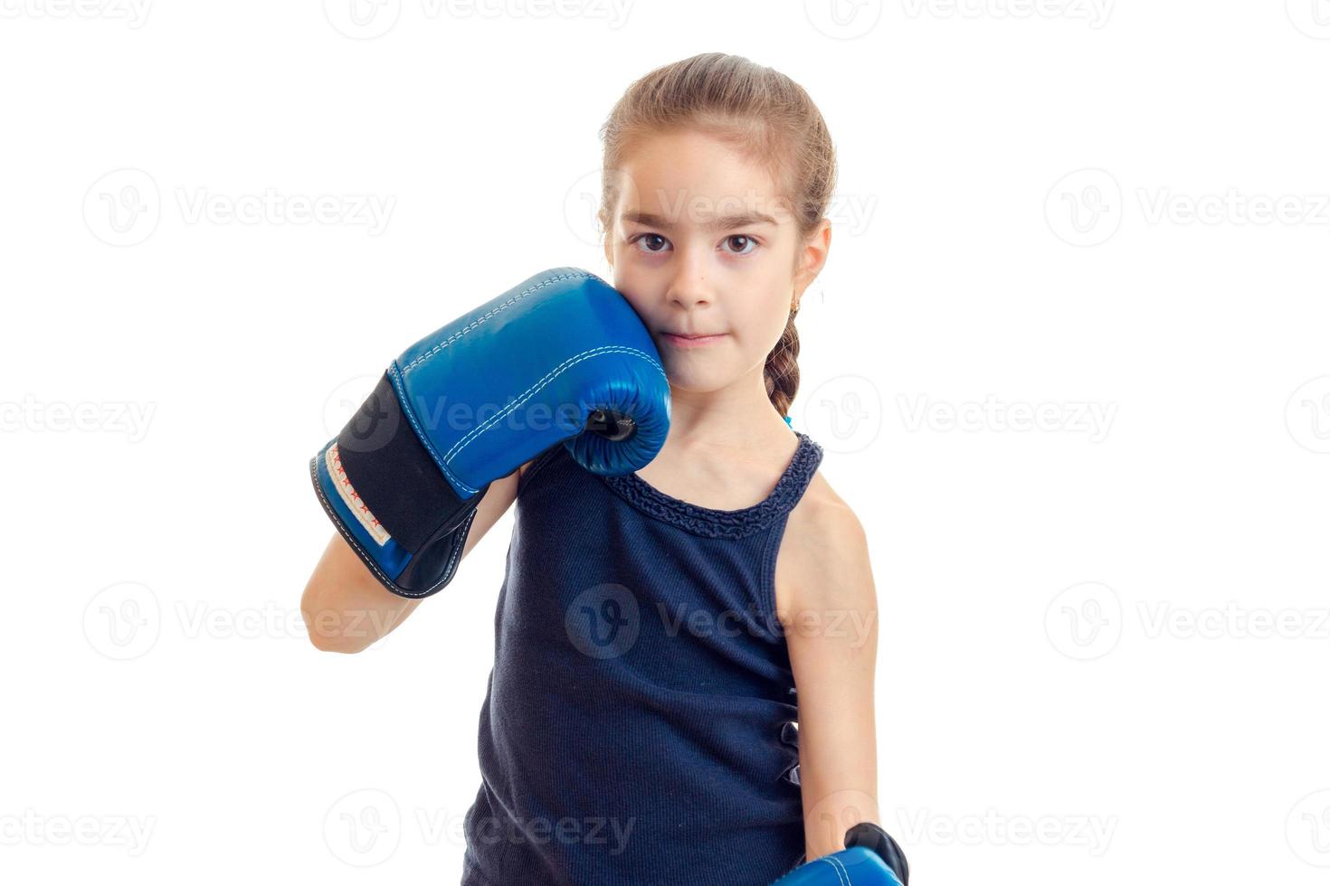 liten söt flicka i boxning handskar utseende på kamera foto