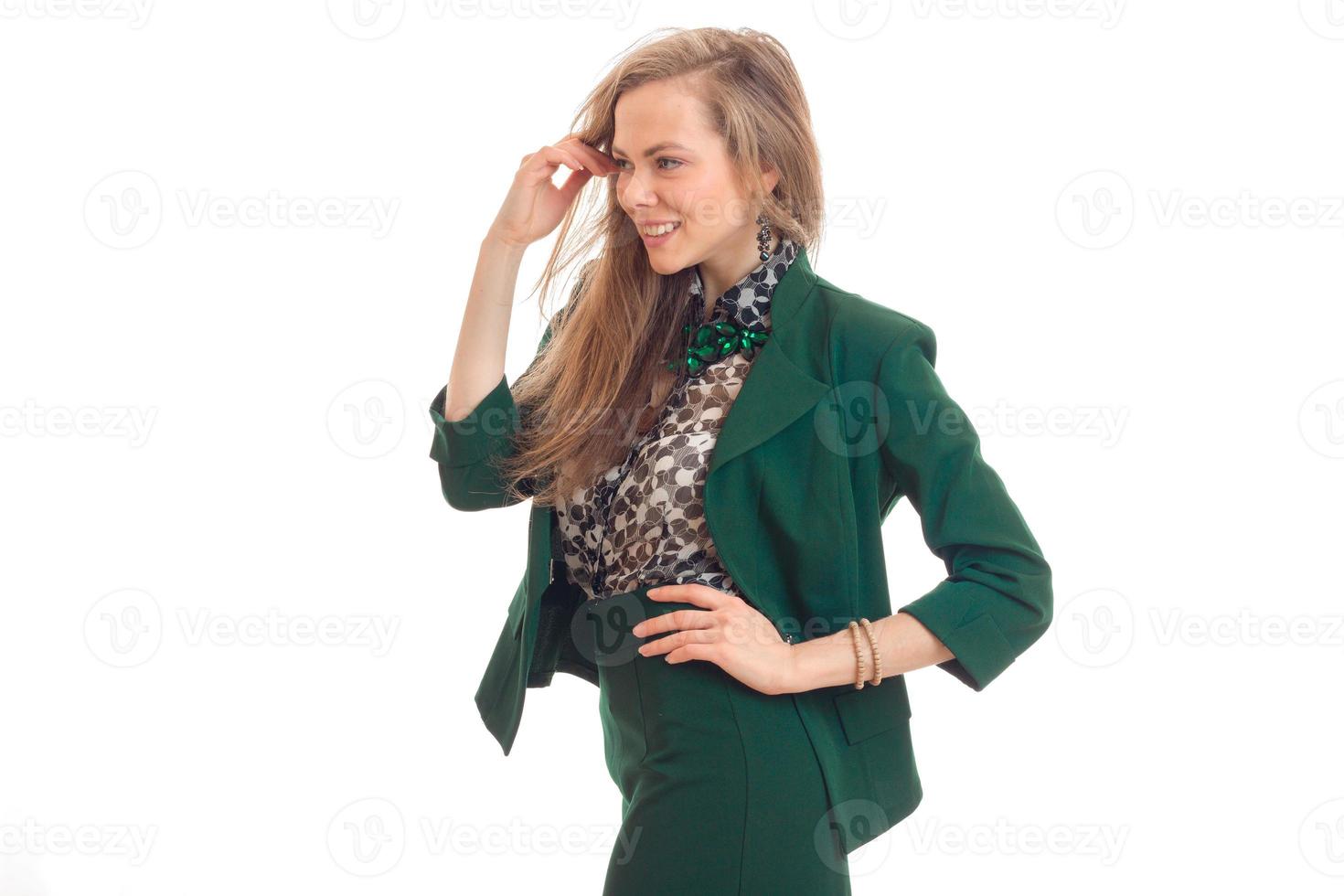 blond i en grön kostym står sidled hade sätta hand på de sida foto