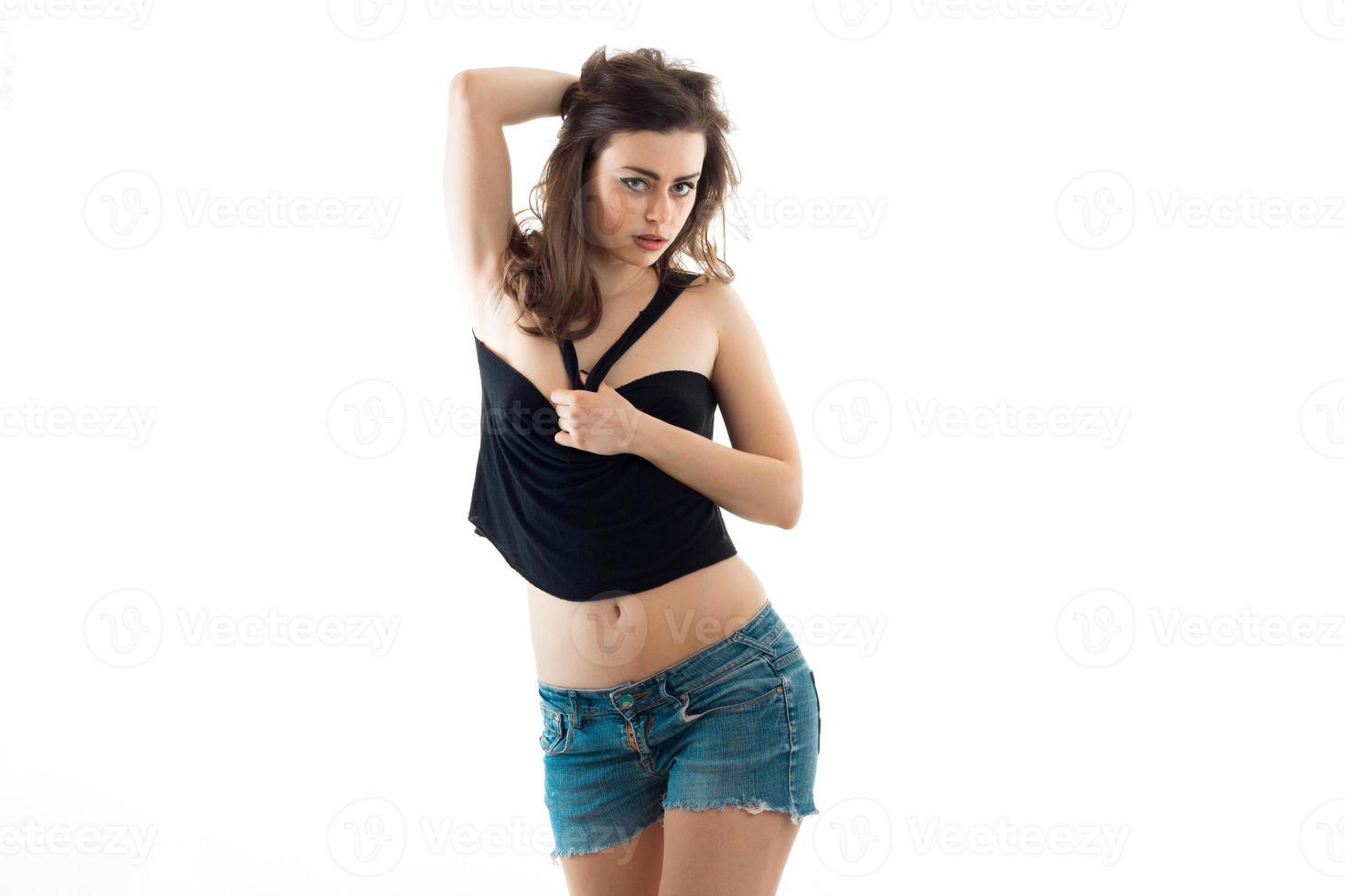 underbar ung brunett i svart t-shirt erotisk håller remmar och utseende in i en kamera foto
