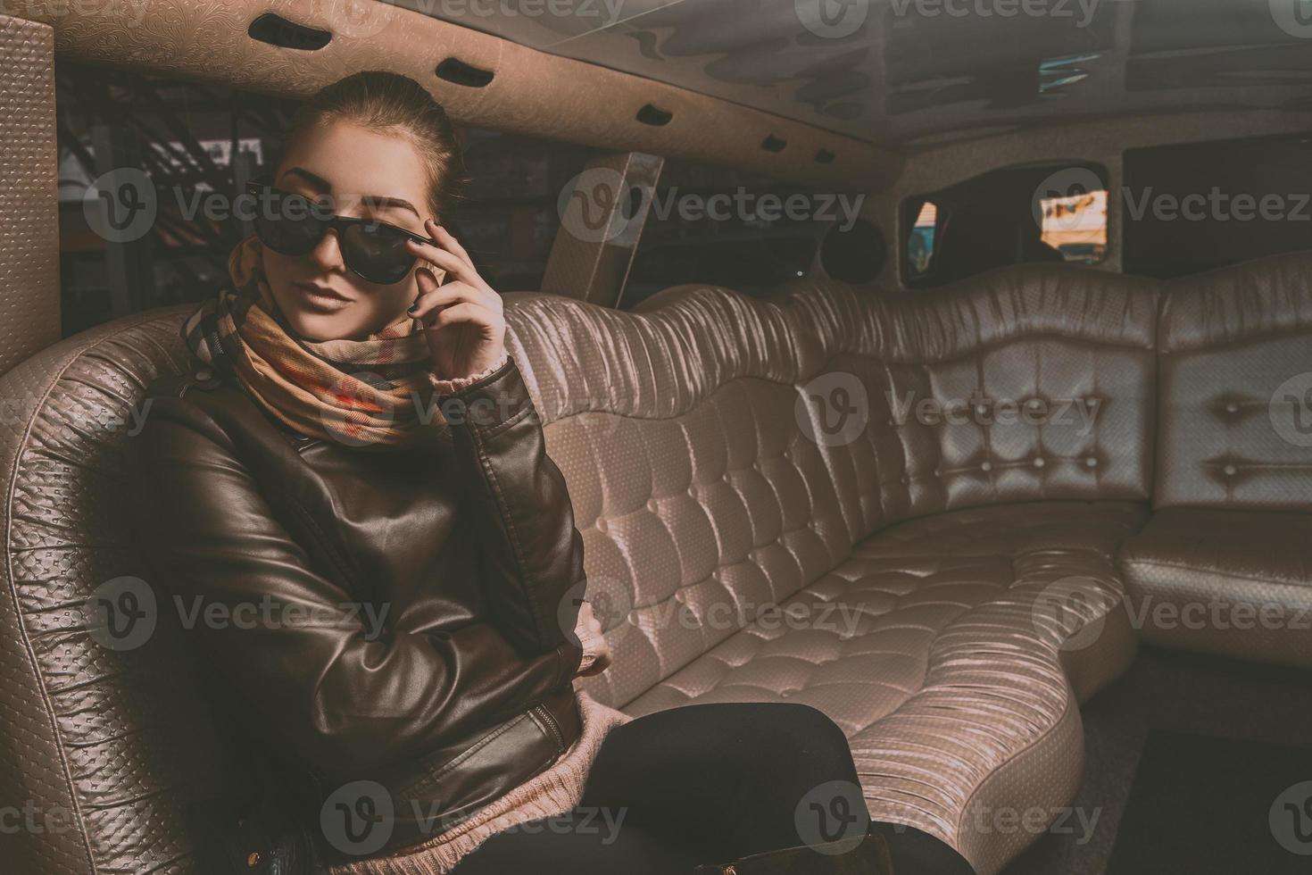 underbar vuxen kvinna ser bort med solglasögon från limousine foto