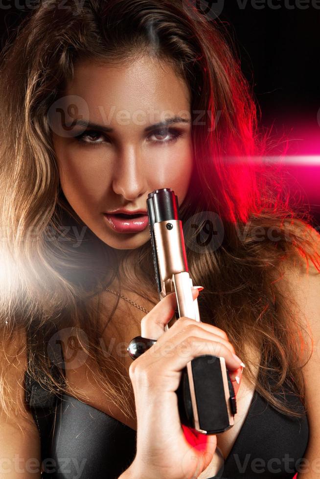 porträtt av sexig ung vuxen kvinna med pistol foto