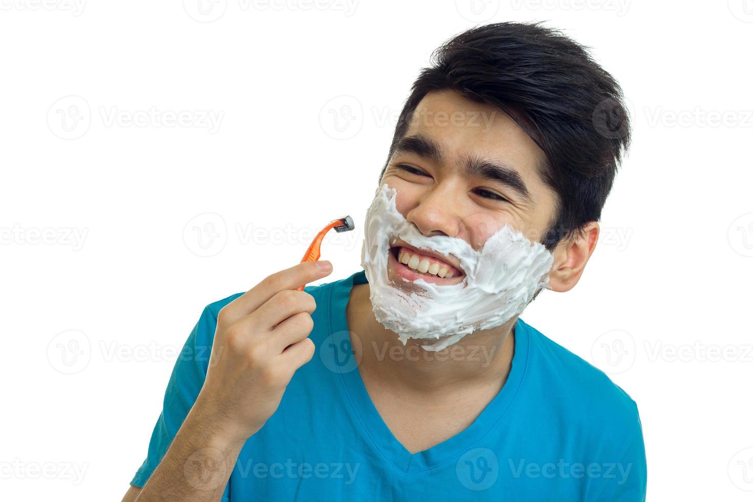 närbild porträtt av en skön glad kille vem orsakade de skum på en skägg och rakar foto