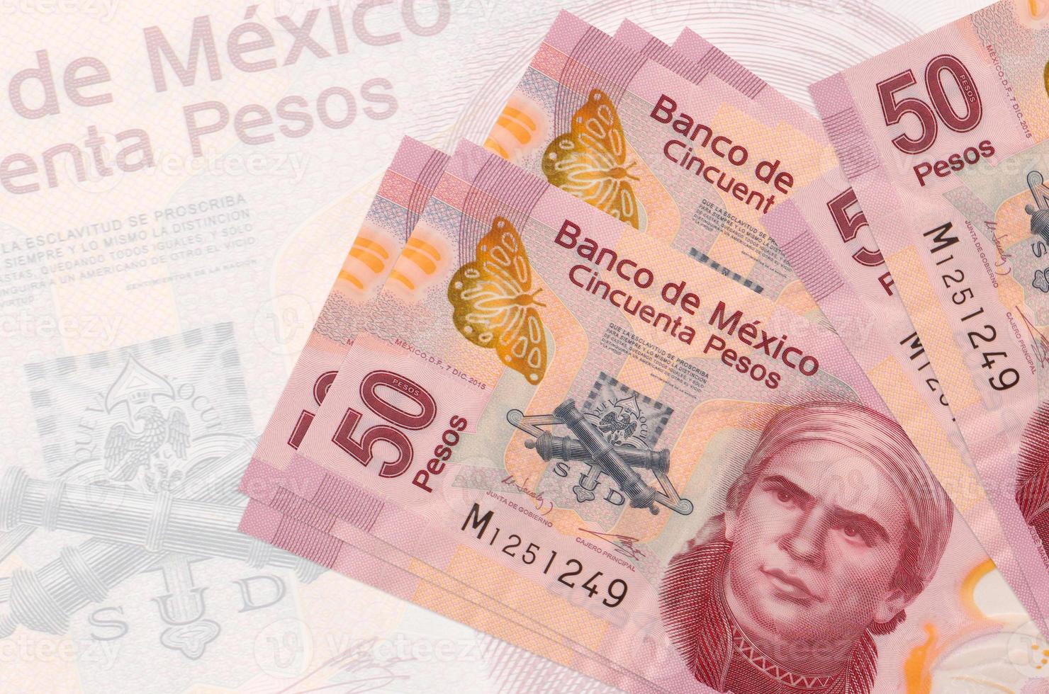 50 mexikansk pesos räkningar lögner i stack på bakgrund av stor halvtransparent sedel. abstrakt presentation av nationell valuta foto