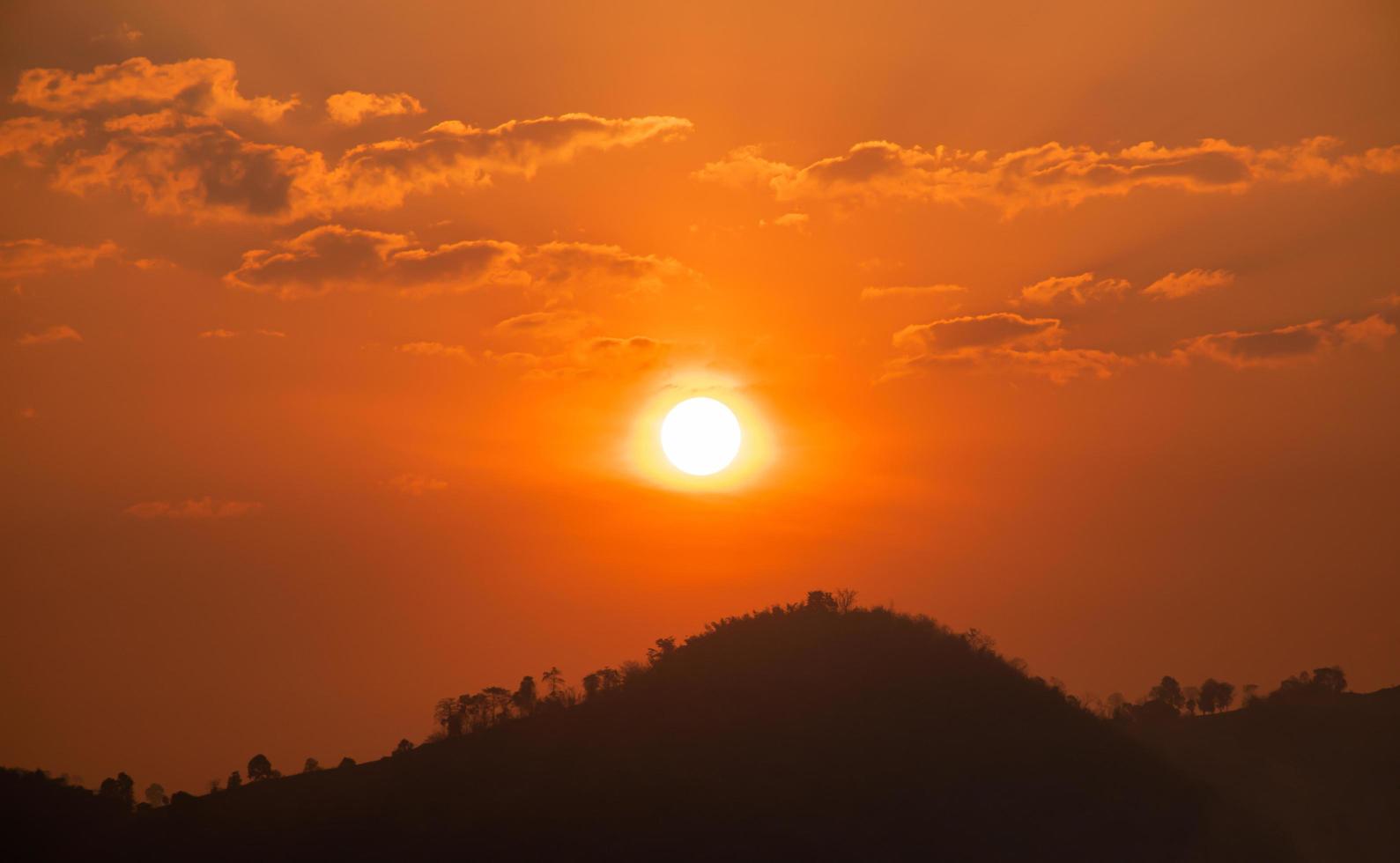 de Sol på de orange himmel i de morgon- och de berg se foto