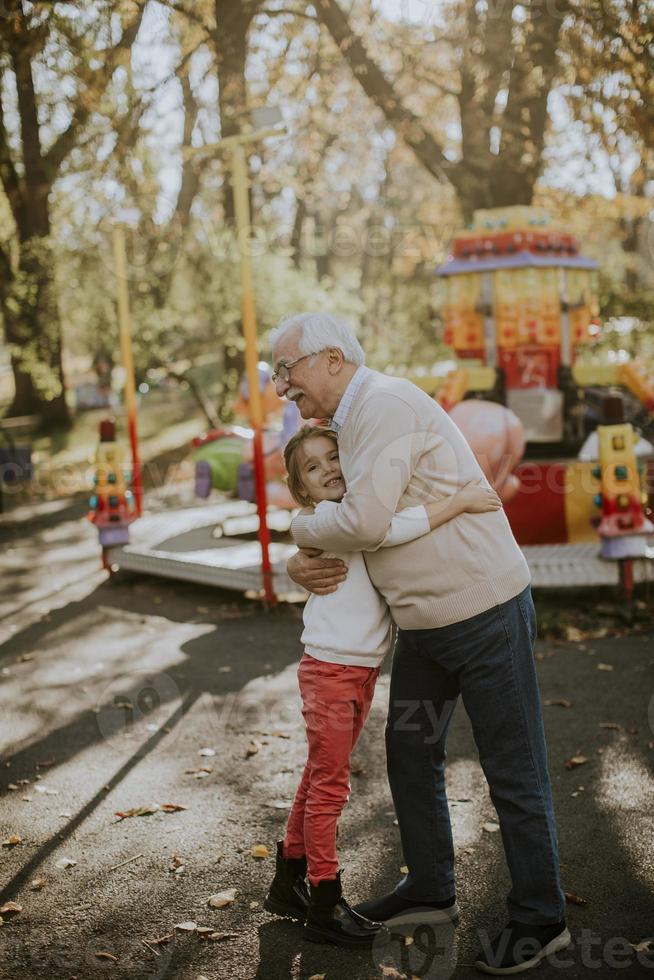 farfar har roligt med sitt lilla barnbarn i nöjesparken foto