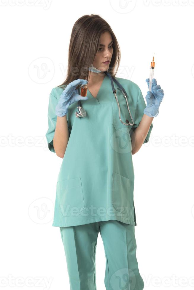 kvinna sjuksköterska med skyddande arbetskläder innehav vaccin och spruta foto