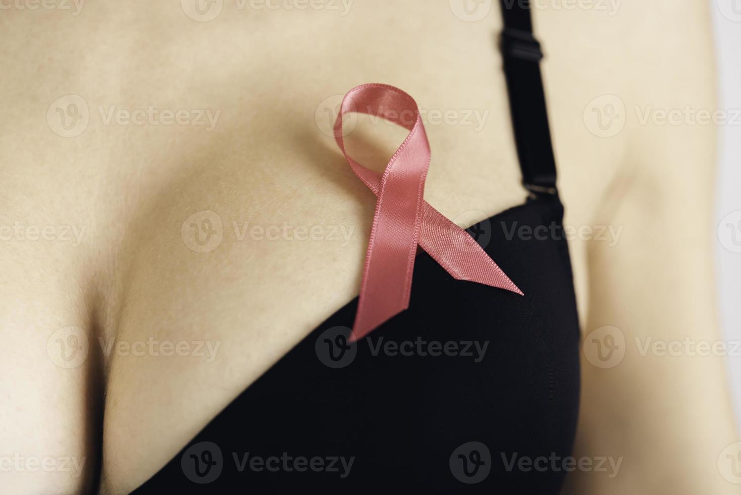 hälsa vård, medicin och bröst cancer medvetenhet begrepp. ung kvinna i behå med rosa band symbol foto