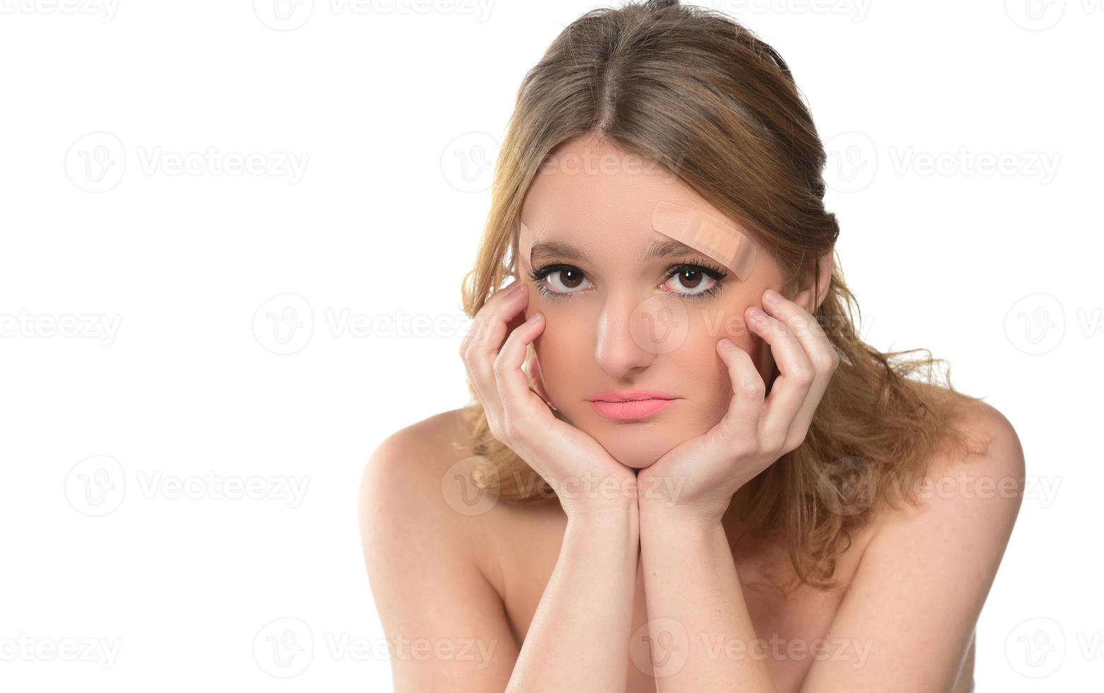 ung kvinna med lim bandage på henne ansikte foto