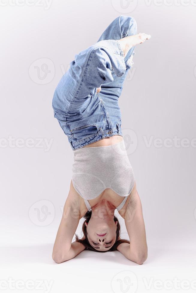 porträtt av skön ung kvinna med atletisk flexibel kropp håller på med ben stretching. isolerat foto