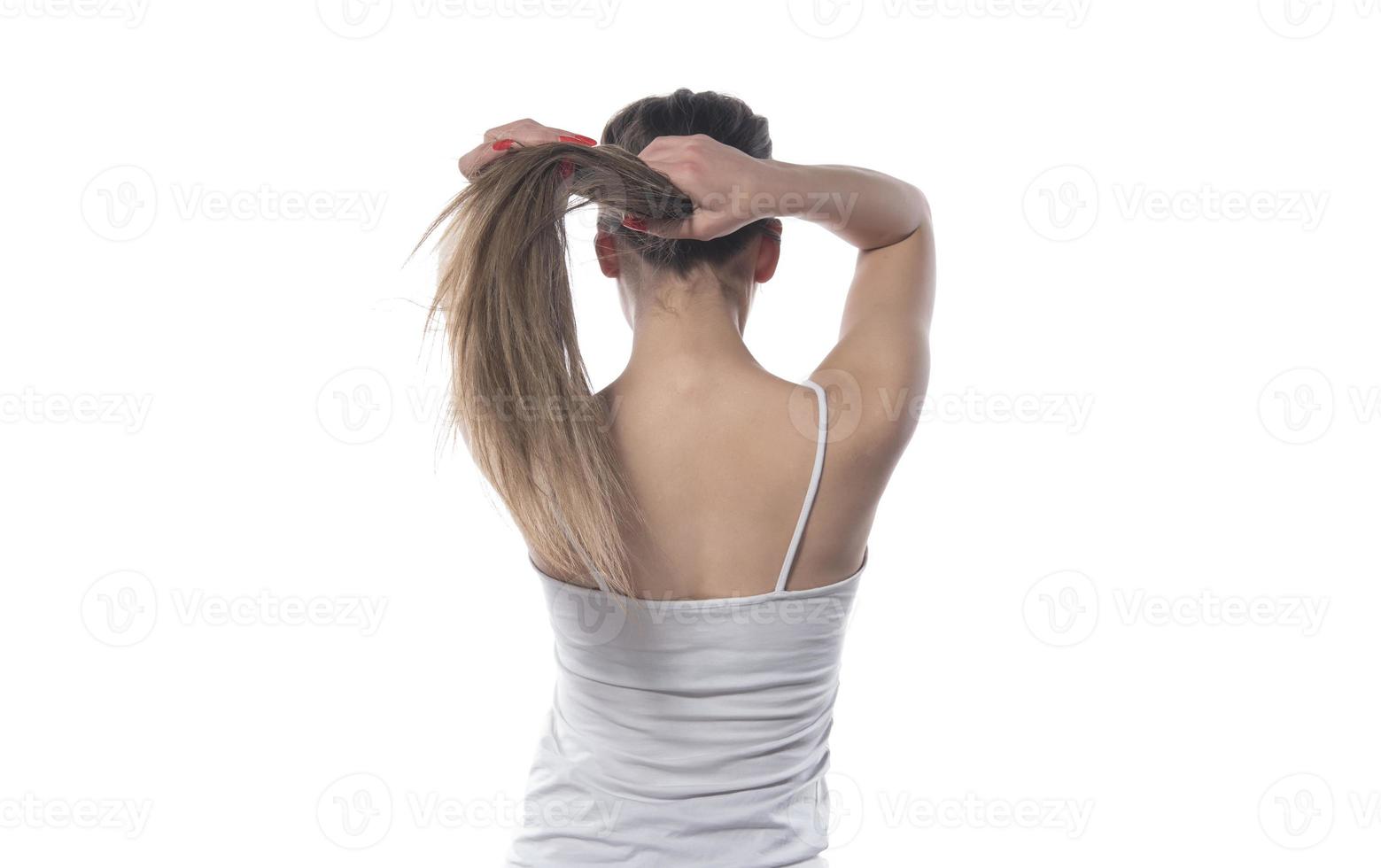 en ung skön kvinna bunden henne hår med en sudd band foto