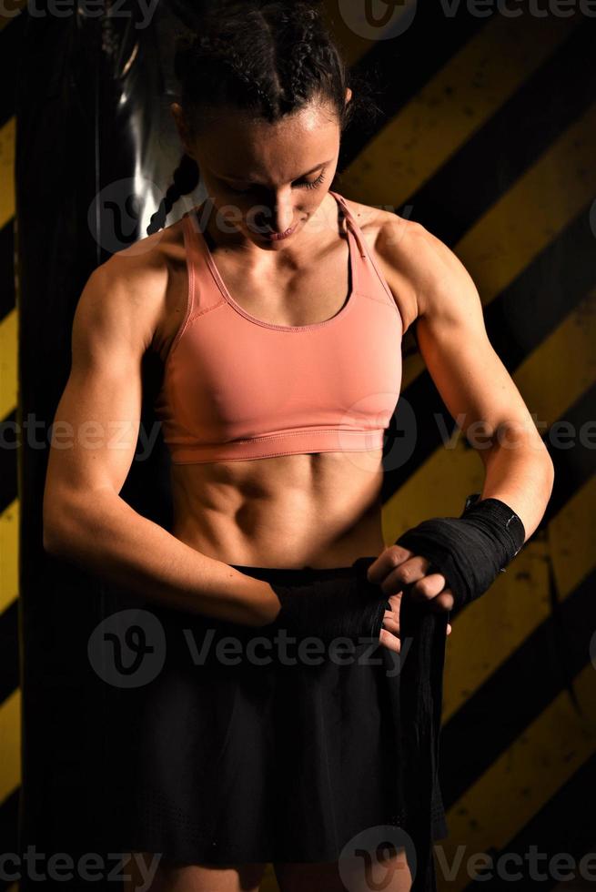 närbild av en kvinna håller på med boxning bandage i en stridande bur foto