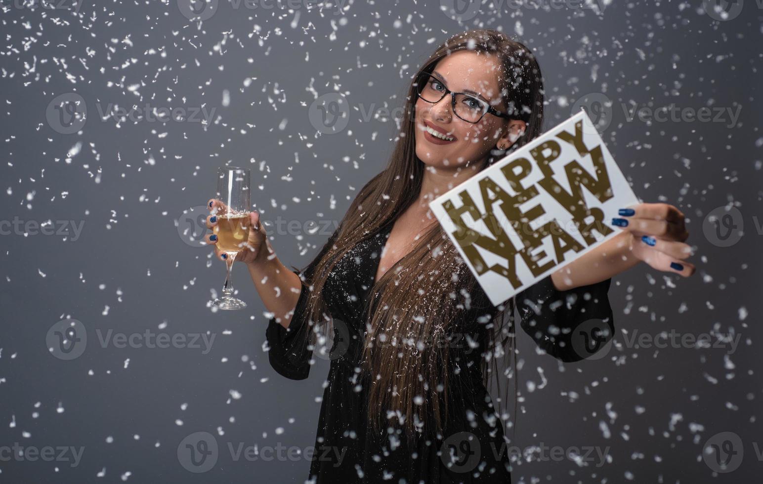 skön kvinna fira ny år med konfetti och champagne innehav tecken. isolerat foto