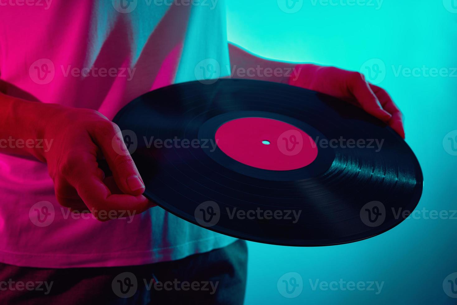 kvinna håll retro vinyl skiva med neon ljus foto