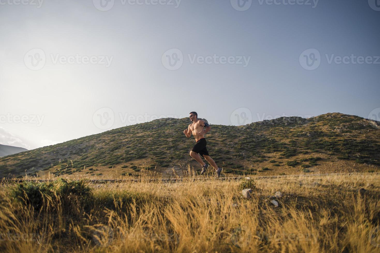 sportig man löpare löpning på berg platå i sommar foto