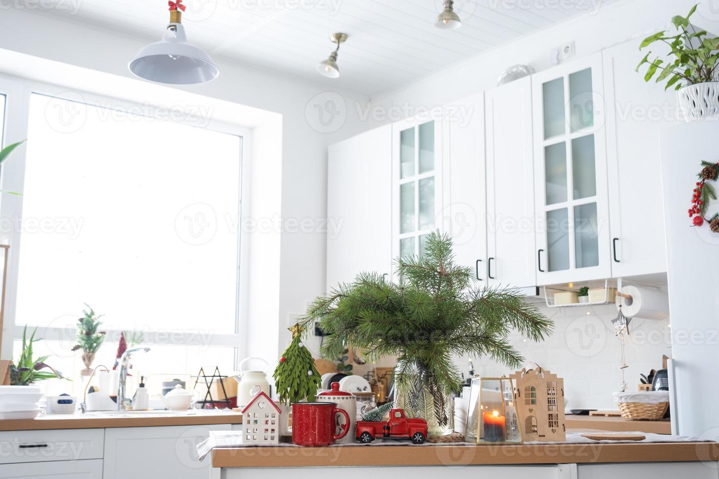 festlig jul dekor i vit kök, festlig frukost, vit scandi interiör. de figur av en mysigt hus Jon de uppsättning tabell. ny år, humör, mysigt Hem. kopia Plats foto