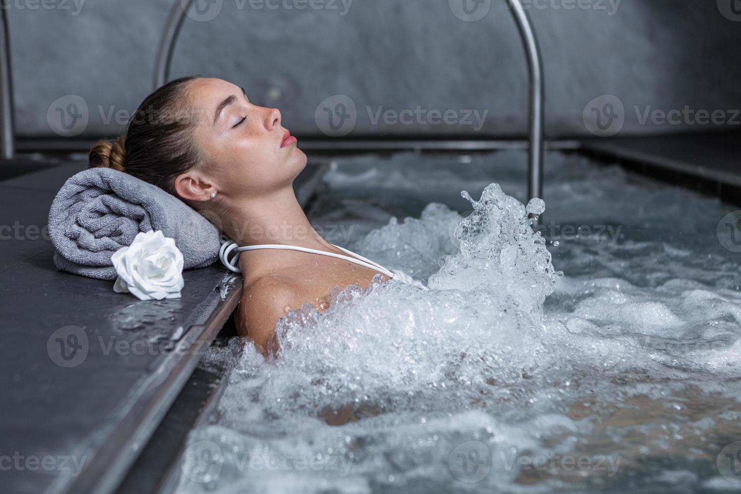 lugna kvinna vilar i bubblande slå samman foto