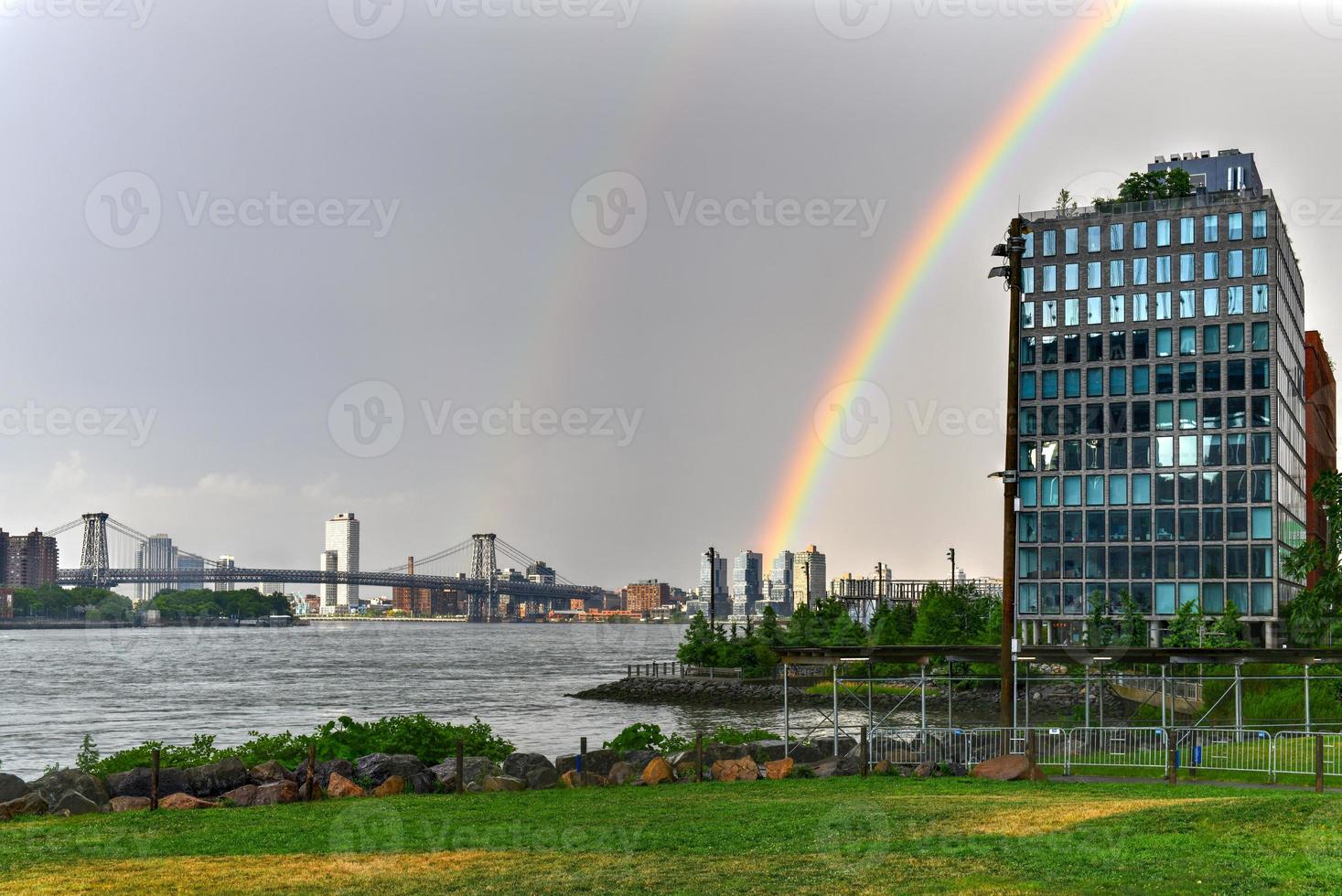 williamsburg bro korsning de öst flod mellan brooklyn och manhattan med en regnbåge i de bakgrund. foto