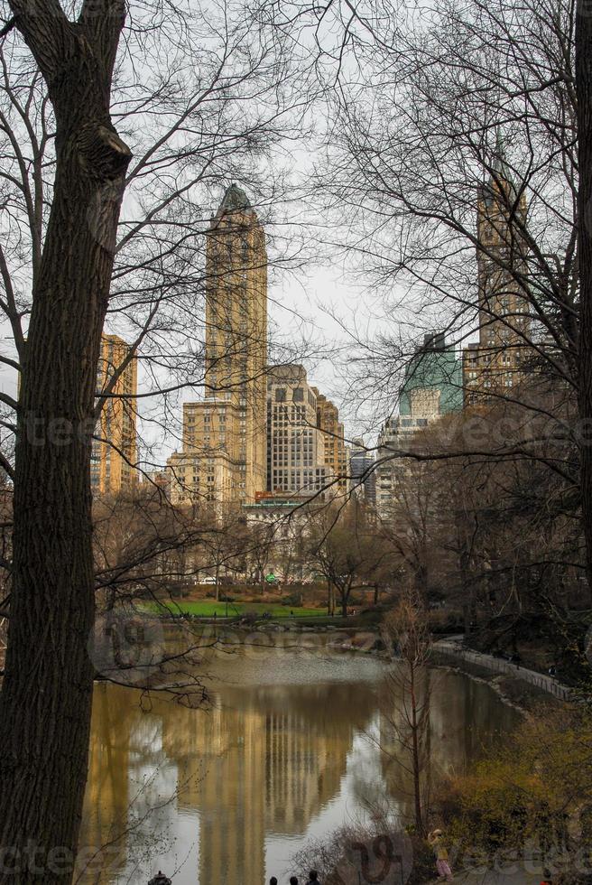 central parkera i ny york stad i de vår. byggnader reflekterad i de damm. foto