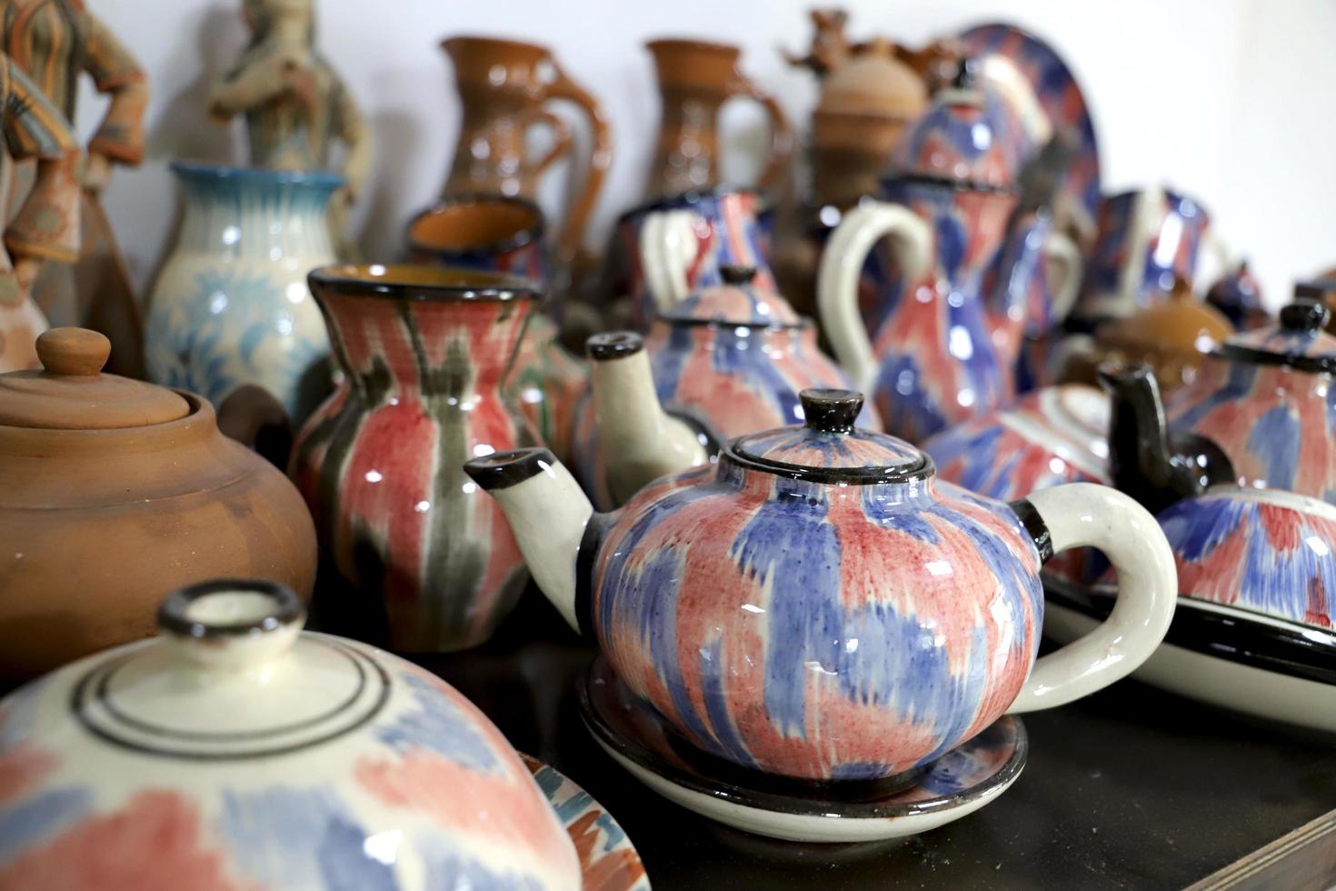 keramisk te kastruller och Övrig varor dekorerad förbi tradition uzbekiska mönster. ofokuserad. foto