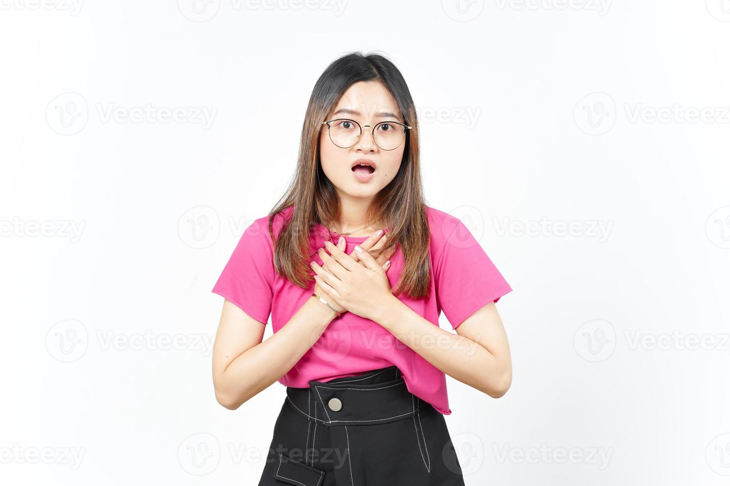 händer på bröst med chockade ansikte uttryck av skön asiatisk kvinna isolerat på vit bakgrund foto