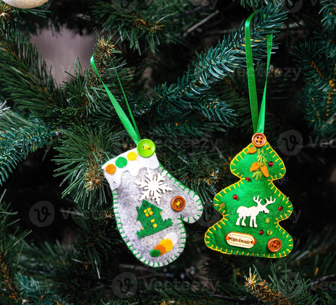 kreativ diy hantverk hobby. framställning handgjort hantverk jul ornament och bollar med känt gran träd. jul träd med färgrik bollar och gåva lådor över vit tegel vägg med blå och vit bollar foto