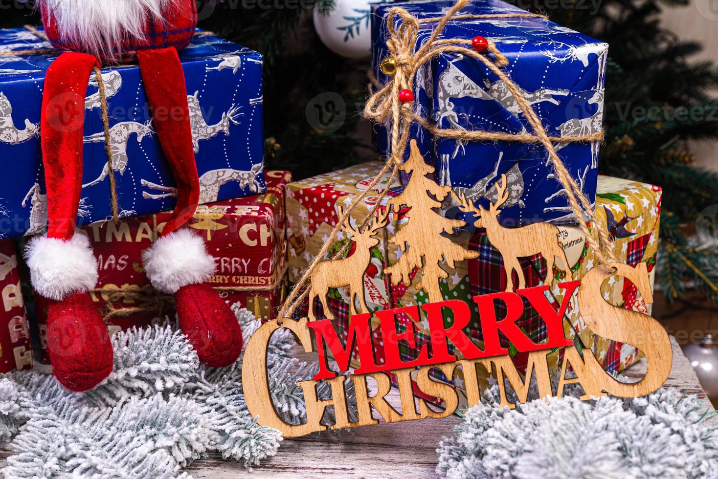 de inskrift vinter- från en träd på en ny år. på de gran grenar mot de bakgrund av en snö omslag är ny år blå, vit bollar med gran koner och en låda med en gåva. jul foto