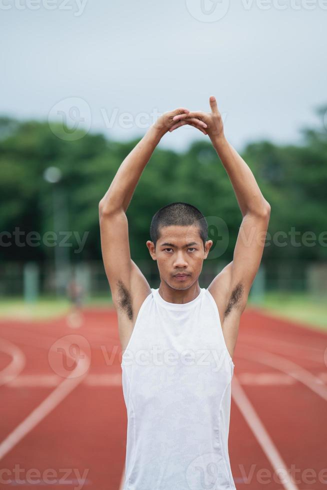 idrottare sport man löpare bär vit sportkläder till stretching och värma upp innan praktiserande på en löpning Spår på en stadion. löpare sport begrepp. foto