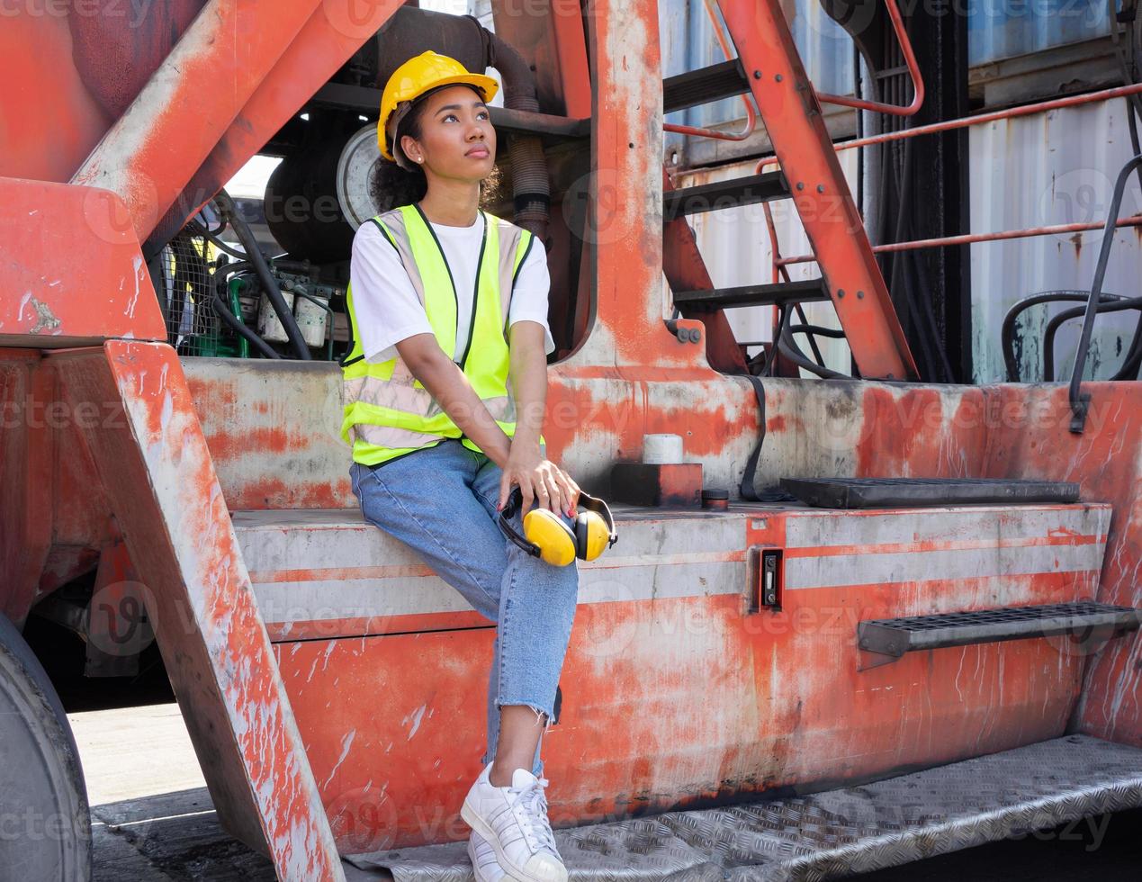 porträtt av raser kvinna industriell ingenjör i hård hatt arbetssätt på logistisk behållare lager. inspektör eller handledare i säkerhet väst är ansvarig för frakt lagring och leverans global handel foto