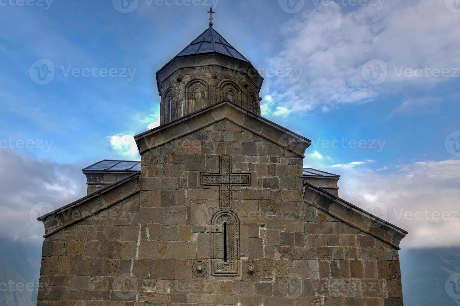 gergeti trinity kyrka, helig trinity kyrka nära de by av gergeti i georgien, under montera kazbegi. foto