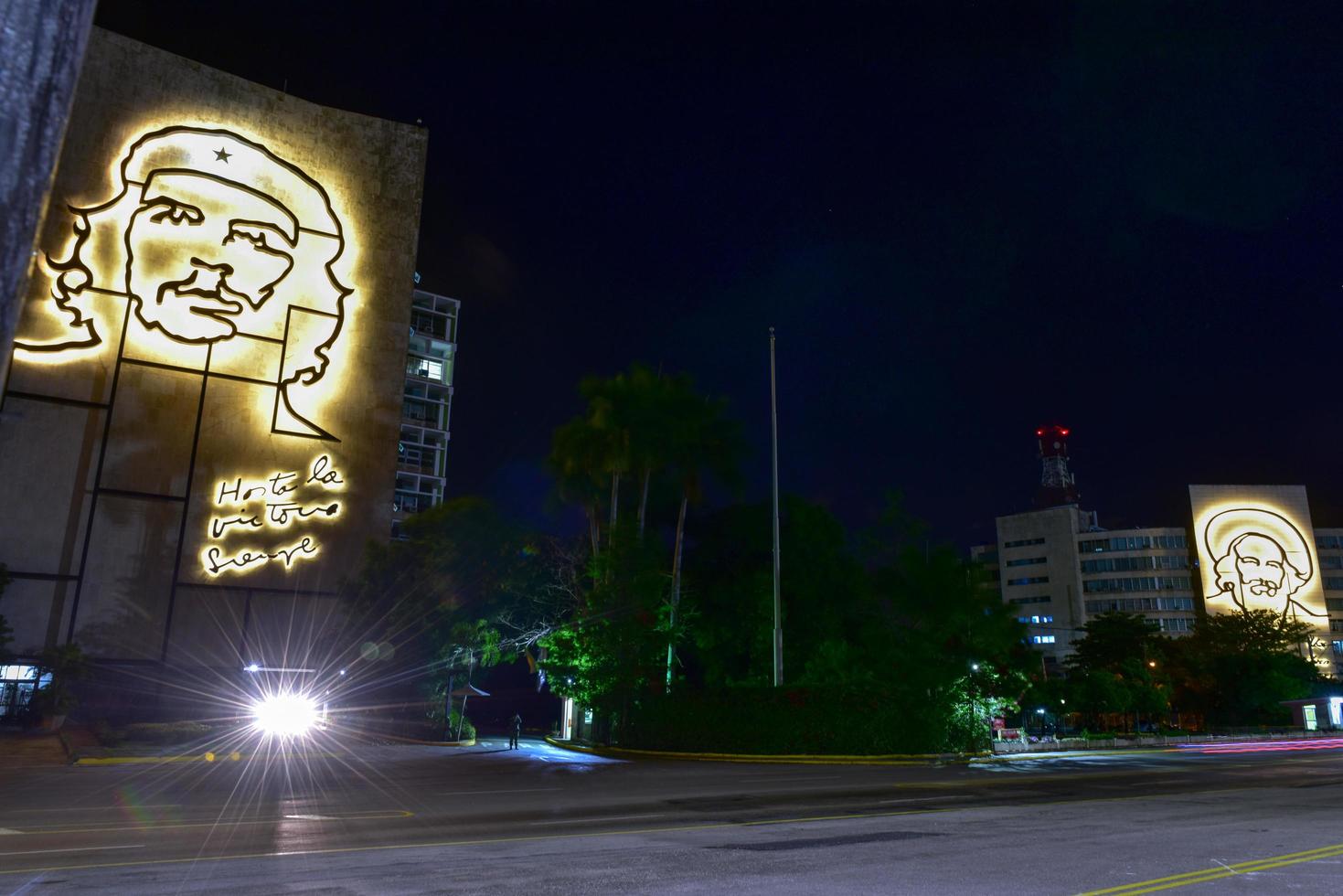 porträtt av che guevara och camilo cienfuegos på de departement av de interiör och de departement av informatik och kommunikation förbi de torg de la revolution i Havanna, kuba på natt, 2022 foto