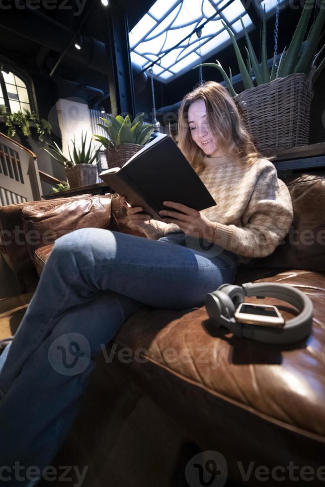 skön flicka, läsning en bok, begrepp av Hem och bekvämlighet foto