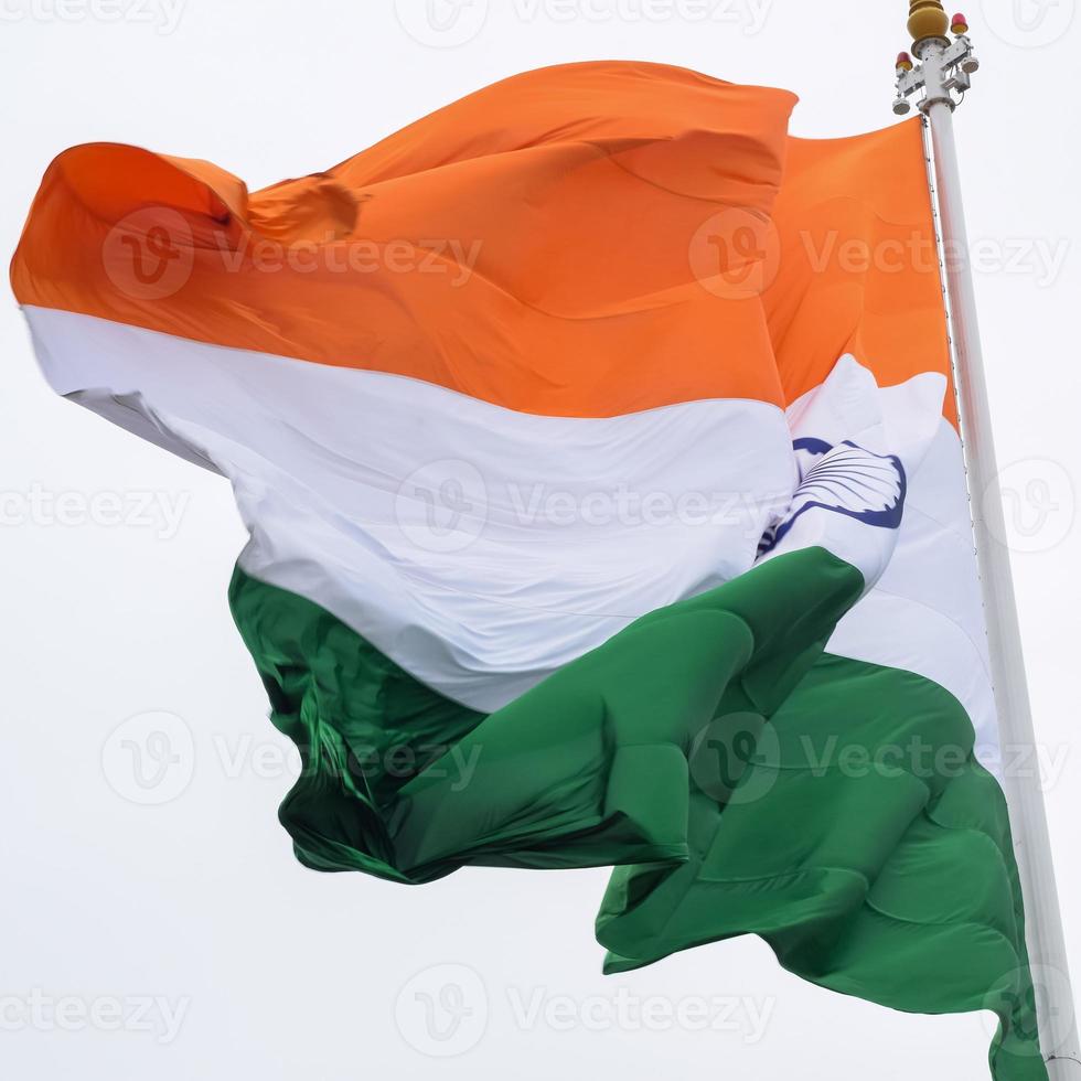 Indien flagga vajar högt på connaught plats med stolthet över blå himmel, Indien flagga vajar, indiska flaggan på självständighetsdagen och republikens dag i Indien, tilt up shot, viftande indiska flaggan, har ghar tiranga foto