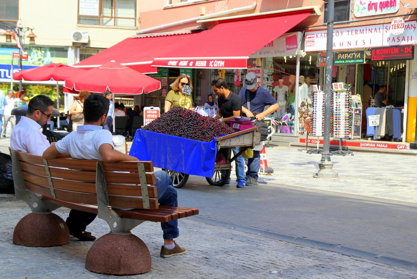 istanbul, Kalkon - juni 29, 2015. Säljare av körsbär med en vagn full av mogen bär i de Centrum av stad. foto