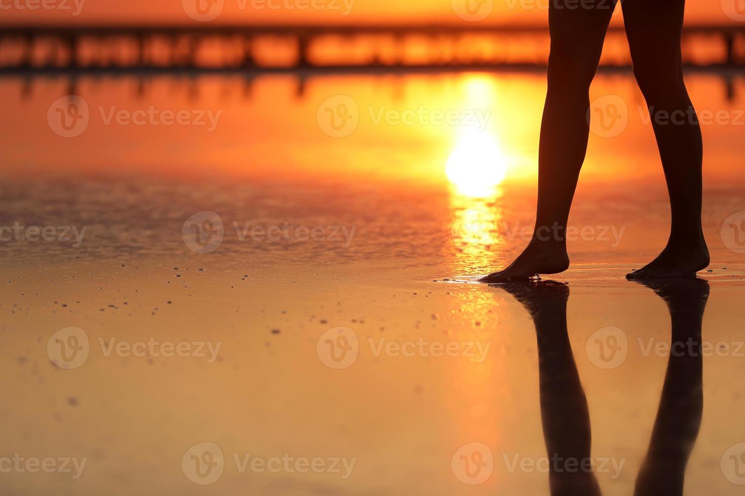 bilder från sidan av vacker ung kvinna i baddräkten som går på stranden mot havet. tjejen är väldigt smal foto