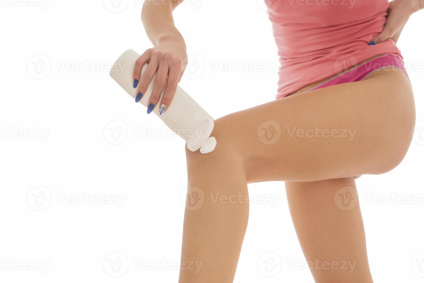 kropp vård. kvinna applicering grädde på ben. kvinna applicering anti celluliter grädde foto