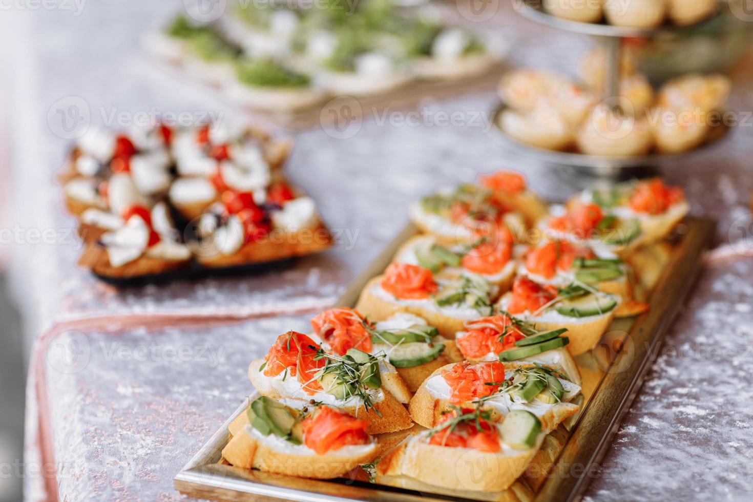 mellanmål. bruschetta med lax, avokado och microgreen groddar på en trä- tallrik foto