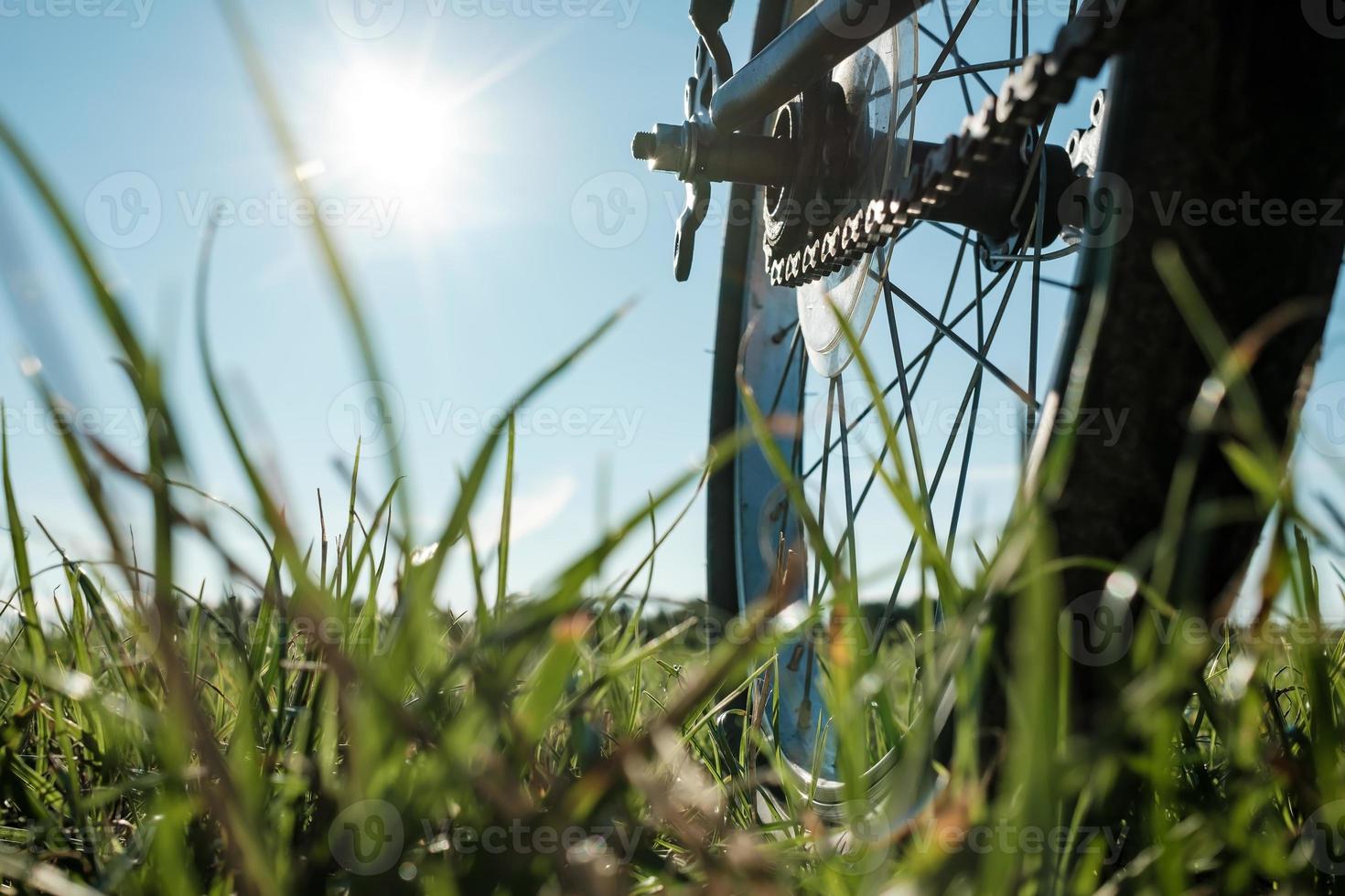 närbild detalj av en cykel parkerad i en äng, mot de bakgrund av de Sol och blå himmel. aktiva livsstil begrepp. botten se. foto