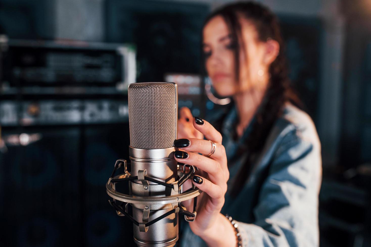 stänga upp se av mikrofon. ung skön kvinna artist övar i en inspelning studio foto