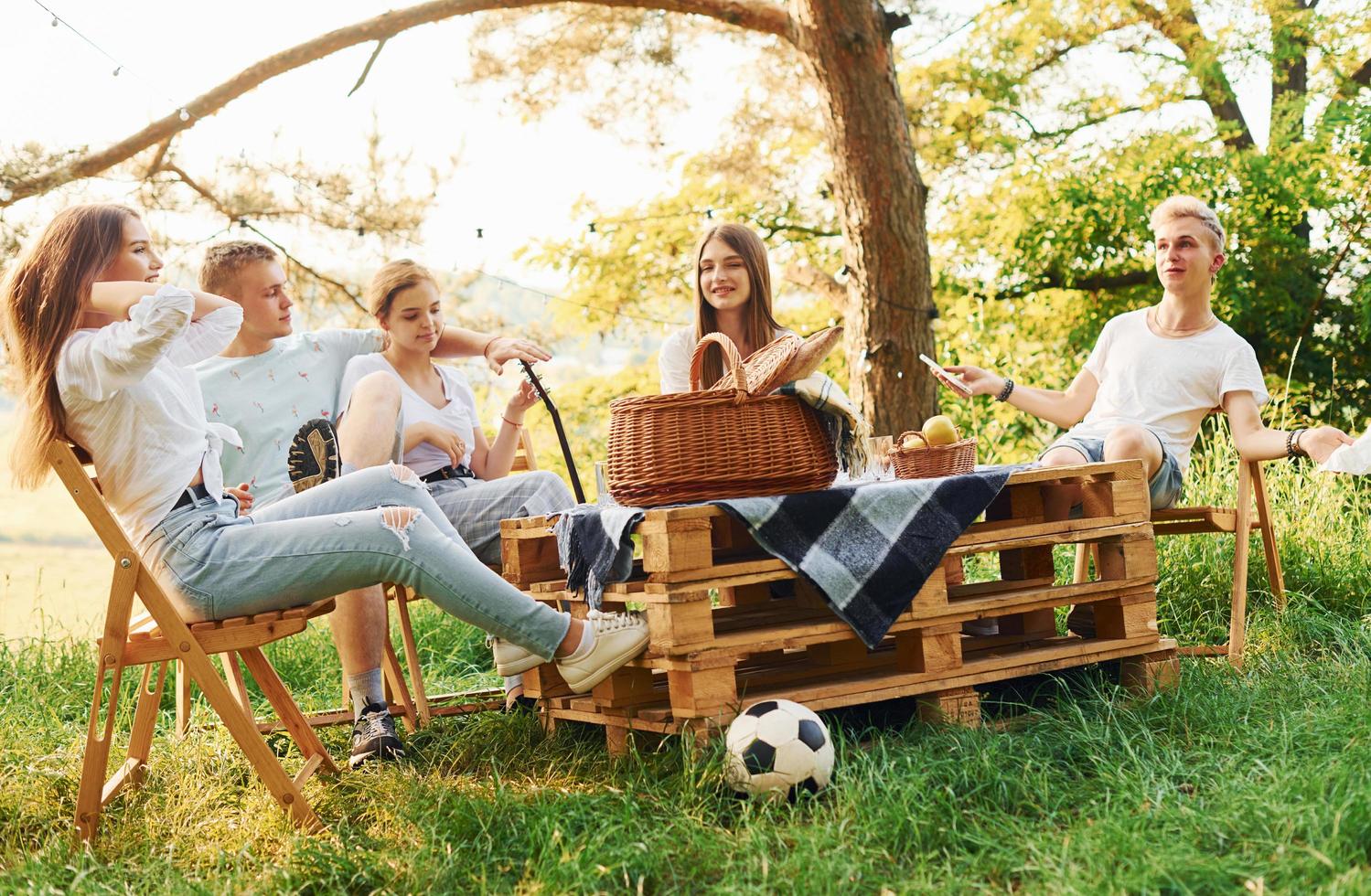 grupp av ung människor ha semester utomhus i de skog. uppfattning av helgen och vänskap foto