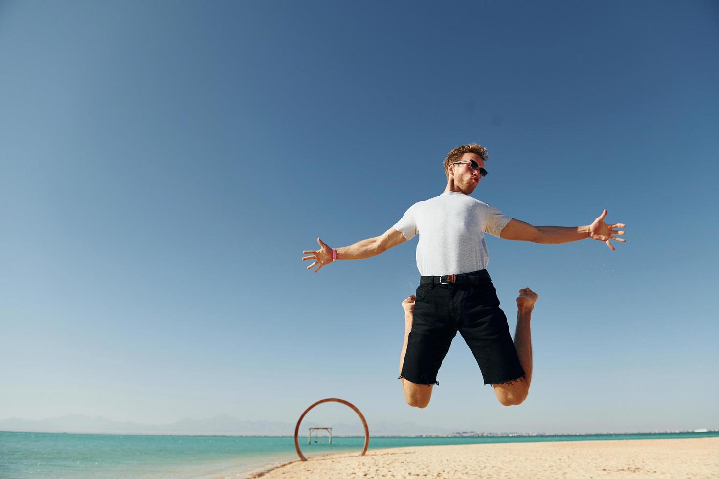 har roligt. ung europeisk man ha semester och njuter fri tid på de strand av hav foto