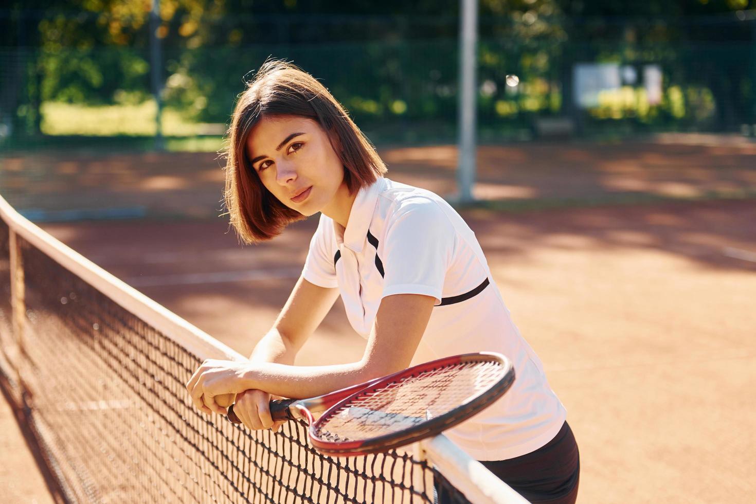 nära de netto. kvinna tennis spelare är på de domstol på dagtid foto