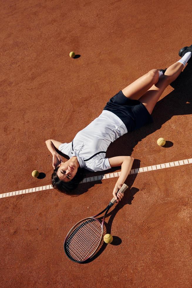 se från ovan. kvinna tennis spelare är på de domstol på dagtid foto