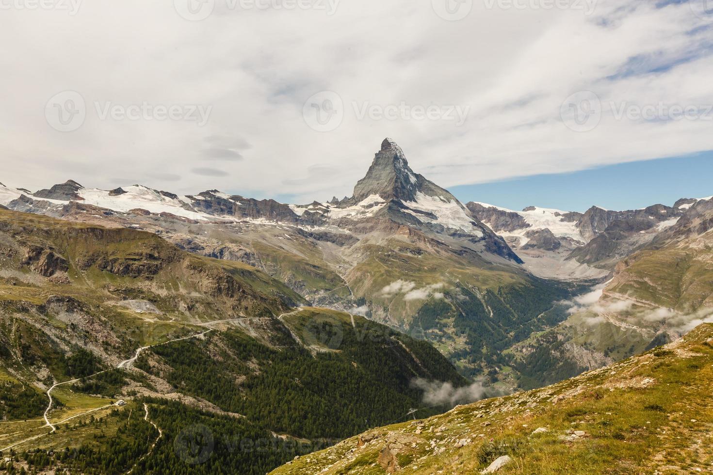 vandring i de swiss alps med blomma fält och de matter topp i de bakgrund. foto