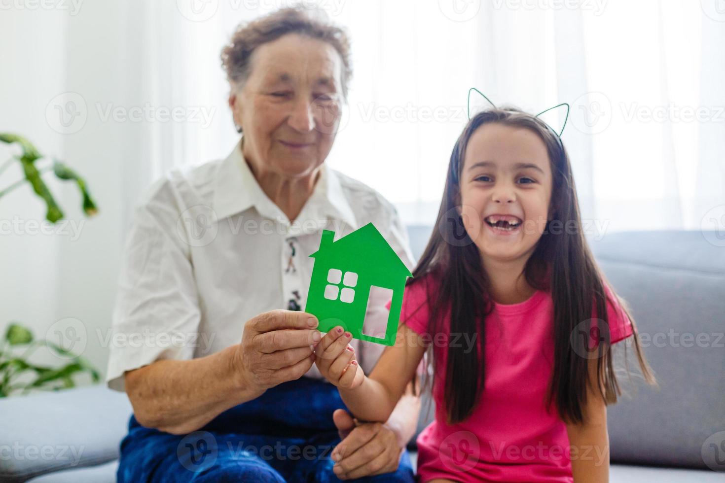 äldre mormor och barnbarn ha kvar en liten hus foto