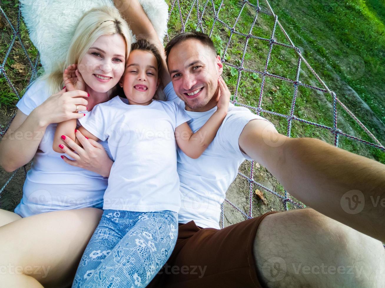 familj avkopplande i trädgård hängmatta tillsammans foto