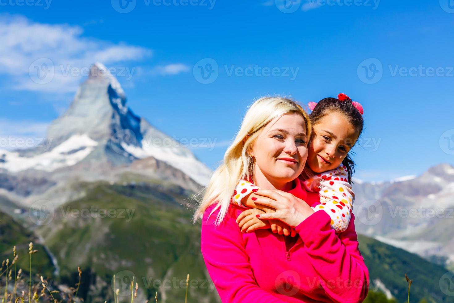 berg resa. två Lycklig flickor på de bakgrund av en berg sjö och bergen i de bakgrund foto